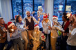 © luckybusiness - happy business team in santa hats celebrating holiday at work.Merry Christmas and Happy New Year