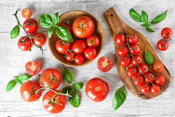 Wall Mural - Fresh red tomatoes on white background or light rustic table. Tomato variety vegetable concept top view