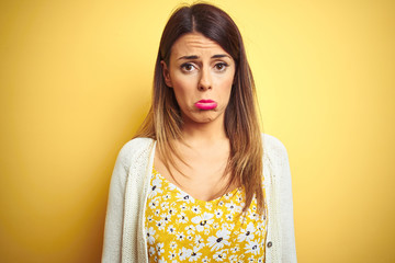 Poster - Young beautiful woman wearing jacket standing over yellow isolated background depressed and worry for distress, crying angry and afraid. Sad expression.