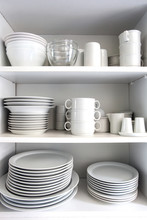 White Cupboard With White Crockery In The Kitchen, Various Clean Dishes