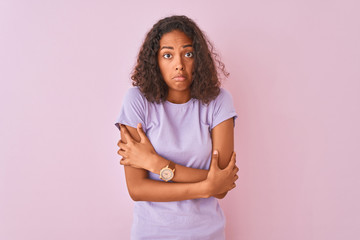 Canvas Print - Young brazilian woman wearing t-shirt standing over isolated pink background shaking and freezing for winter cold with sad and shock expression on face