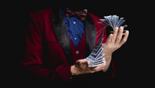 Magician Shows Trick With Playing Cards On Dark Background, Concept Stand-up