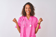 Young brazilian nurse woman wearing stethoscope standing over isolated white background celebrating surprised and amazed for success with arms raised and open eyes. Winner concept.