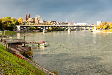 Rhine river and old fishing hut in Basel Switzerland and with Old city center of Basel with Munster cathedral in the background