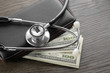 Stethoscope on wallet and dollar banknote money. Concept of health care costs finance