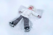Cute girl child makes snow angel at winter park