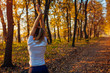 © maryviolet - Training and exercising in autumn park. Woman stretching arms outdoors. Active healthy lifestyle