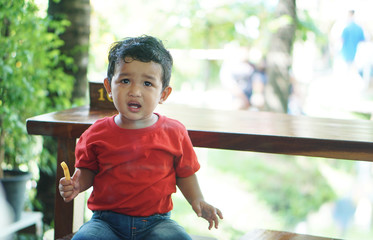 Portrait of cute happy Asian kid looking some one around.