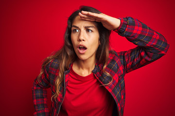 Wall Mural - Young beautiful woman wearing casual jacket standing over red isolated background disgusted expression, displeased and fearful doing disgust face because aversion reaction. With hands raised