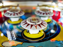 Antique Pinball Machine Bumpers With Motion Blur Ball