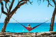 Young woman in hammock on remote beach on beautiful sunny day in Maui, Hawaii