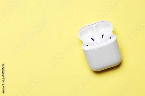 Cuadros en Lienzo Wireless headphones on a yellow background with place for text.