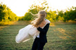 Outdoor dancing with bride in hands, on sunny marriege day in field