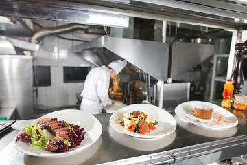 Wall Mural - the distribution table in the kitchen of the restaurant. the chef prepares a meal on the background of the finished dishes.