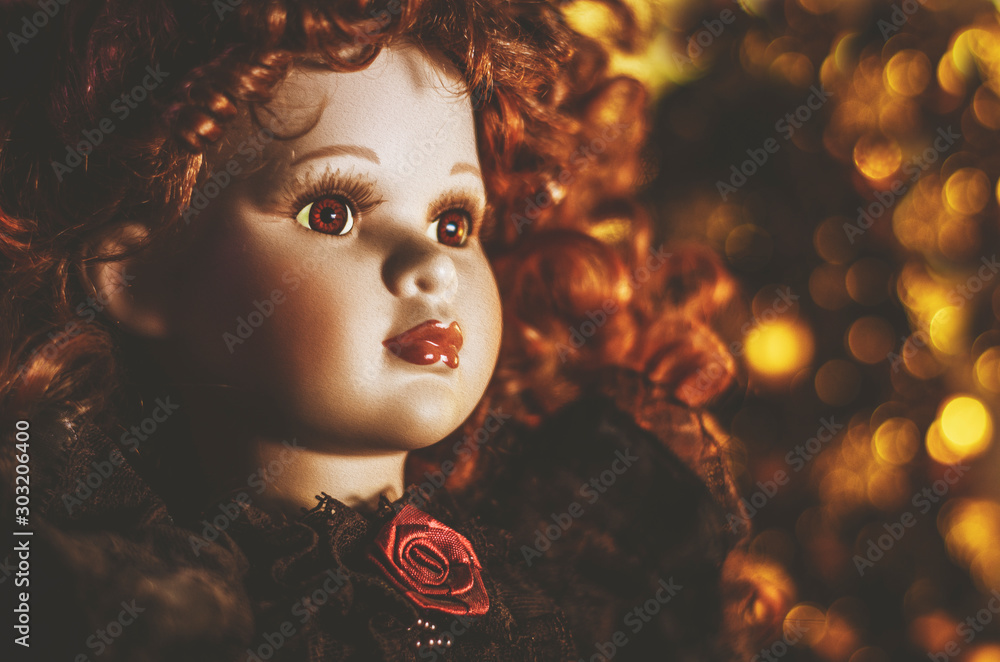 Porcelanowa lalka w blasku świątecznych świateł.  - obrazy, fototapety, plakaty 