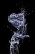 The hand made of water is keeping heart made of water on the black background. Happy Valentine's Day