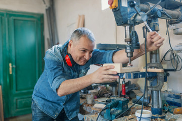 man engineer stand near saw machine to make furniture at carpenters workshop. Handmade business at small furniture factory. man working with  machine inside workshop