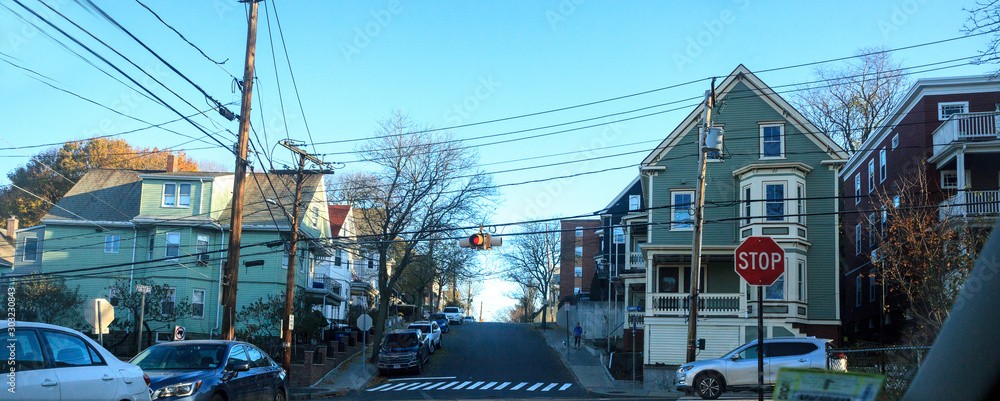 Tree-lined street in a rural Somerville neighborhood in the Fall in the outskirts of Boston. - obrazy, fototapety, plakaty 