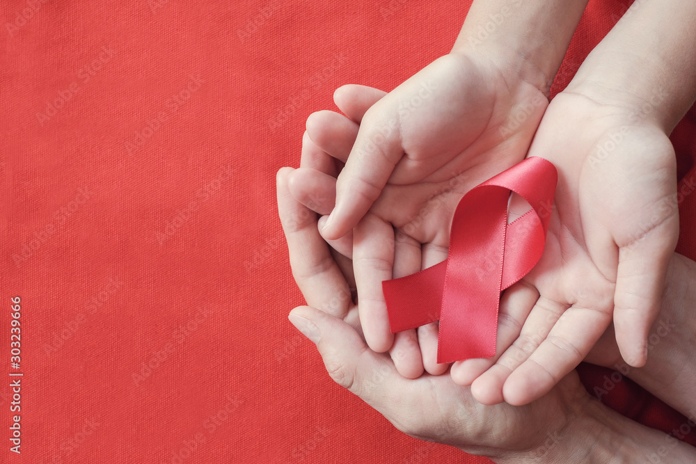 Hands holding red ribbon on red background, hiv awareness concept, world AIDS day, world hypertension day - obrazy, fototapety, plakaty 