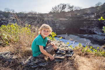 Young boy tourist near Broken Beach in Nusa Penida, Indonesia Angel's BillaBong Beach. Popular tourist destination Bali. Traveling with children concept