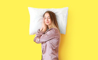 Wall Mural - Sleeping young woman with pillow on color background