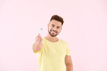 Wall Mural - Portrait of man with toothbrush on color background