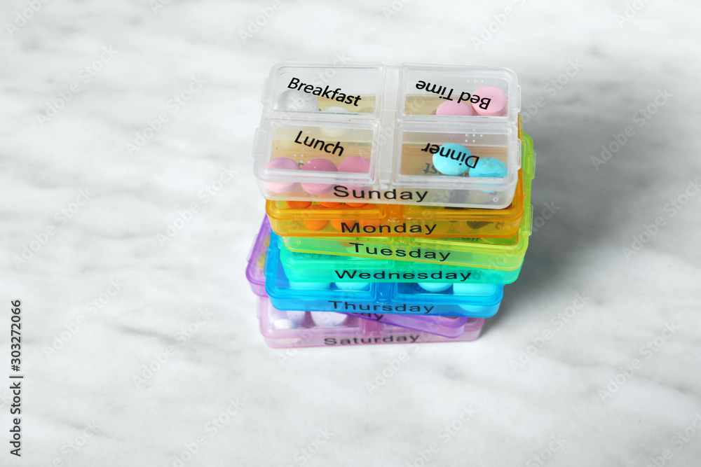 Containers with different pills on light background
