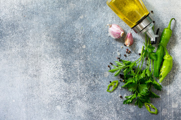 Wall Mural -  Parsley, chili pepper, garlic, sea salt and others with olive oil on a stone table. Top view flat lay background. Copy space.