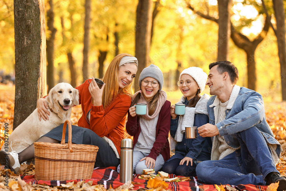 Happy family having picnic in autumn park