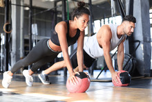Beautiful Young Sports Couple Is Working Out With Medicine Ball In Gym.