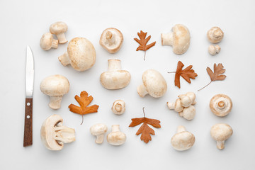 Fresh mushrooms with knife on white background