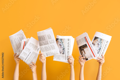 Cuadros en Lienzo Female hands with newspapers on color background