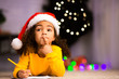 © Prostock-studio - Pensive little black girl thinking what to ask from Santa Claus