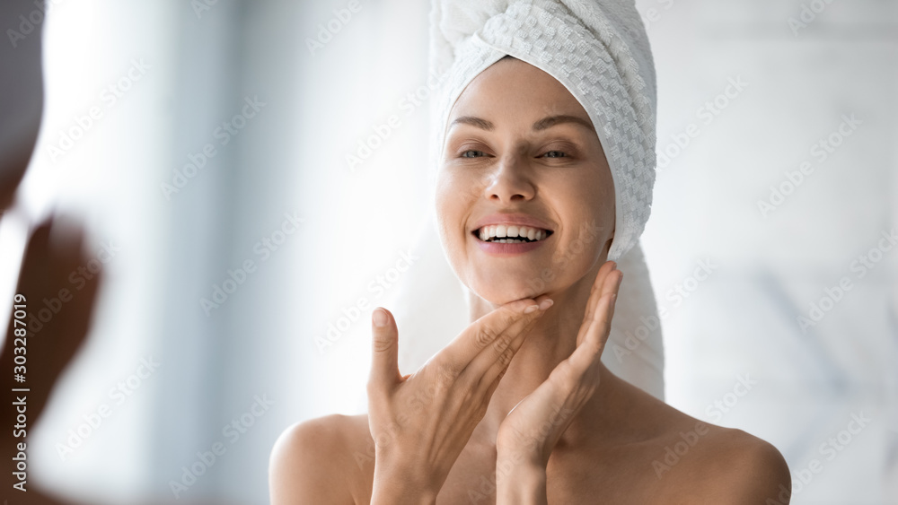 Happy lady look in bathroom mirror touching healthy face skin - obrazy, fototapety, plakaty 