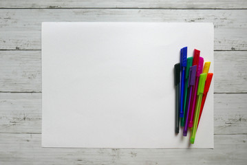 Variety color of ball pen on white paper background lay on white wooden background. Copy paste for text, logo and etc.