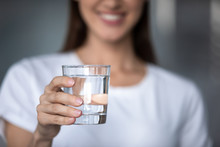 Smiling Young Lady Holding Glass Of Water, Close Up View
