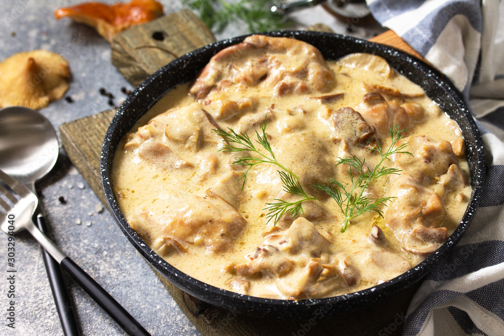 Fricasse - French Cuisine. Chicken stewed in a creamy sauce with mushrooms in a pan on a light stone background. - obrazy, fototapety, plakaty 