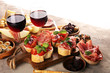 © beats_ - Italian antipasti wine snacks set. Cheese variety, Mediterranean olives, seafood salad, Prosciutto di Parma, tomatoes, anchovy and wine in glasses