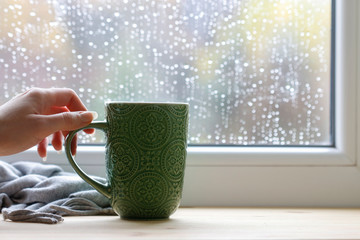 Sticker - Woman holds a green mug with tea.