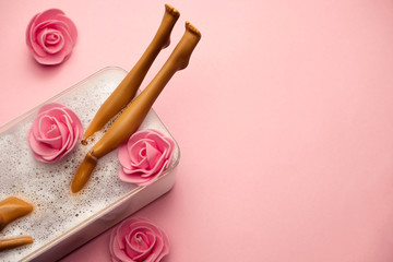 top view plastic doll having a bath , spa concept on a pastel  pink background