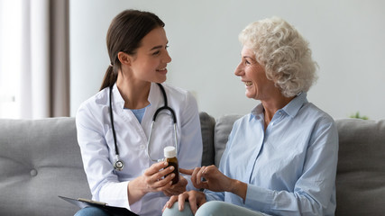 Smiling woman doctor prescribing medicine to happy senior grandmother patient