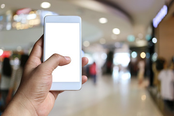 Hand of a man holding smartphone device in the blur Shopping mall background.