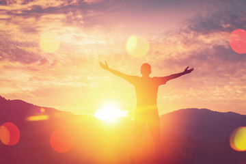 Wall Mural - Copy space of man rise hand up on top of mountain and sunset sky abstract background.