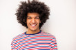 Close up handsome young North African man in striped sweater smiling by white background