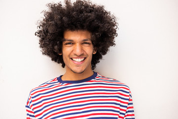 Wall Mural - Close up handsome young North African man in striped sweater smiling by white background