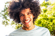 © mimagephotos - young North African man with afro hair laughing outside