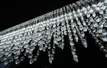 Wall Mural - Chandelier with glass beads on a black background, close-up