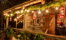 Tiny And Cozy House Cabin Exterior With Christmas Lights. Ideal Picture That Brings Up Holiday Spirit.