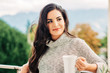 © annanahabed - Romantic portrait of beautiful young woman wearing grey pullover, relaxing on the balcony, holding cup of tea or coffee