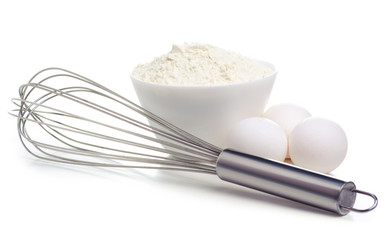 White bowl with flour and eggs, whisk on white background isolation